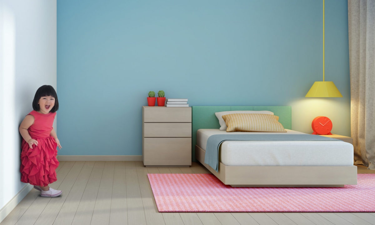 little girl is standing against  wall  inthe bedroom