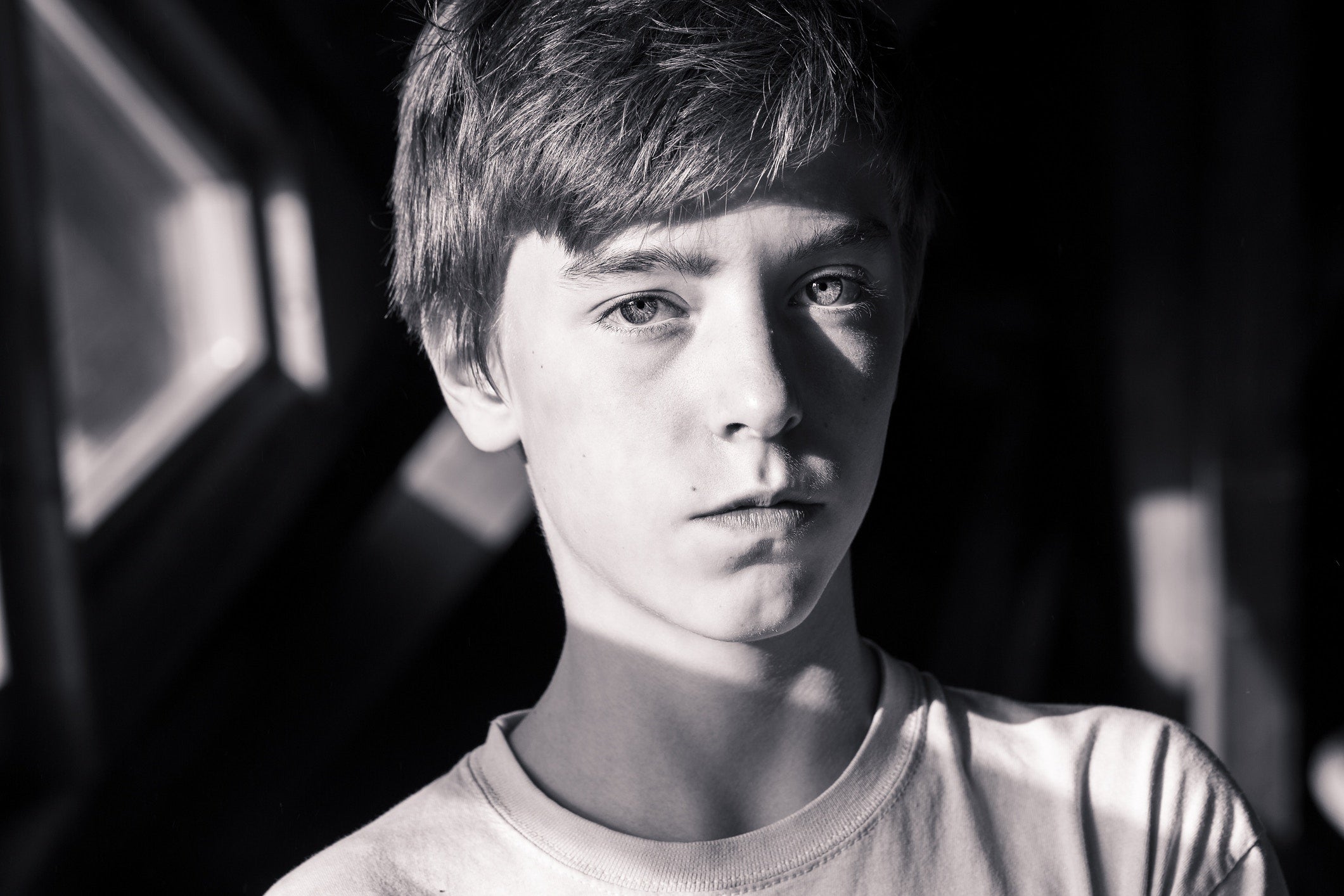 a boy looking at the camera in the park in sun rays