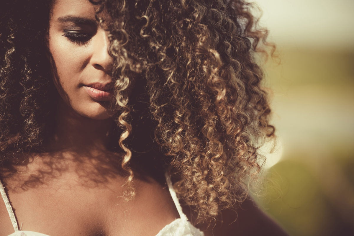 woman portrait with curly hair in the sunlight
