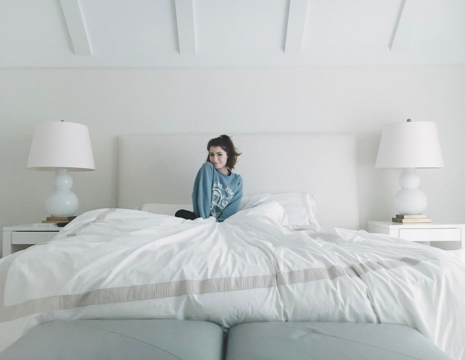 Girl posing while sitting on bed in the morning