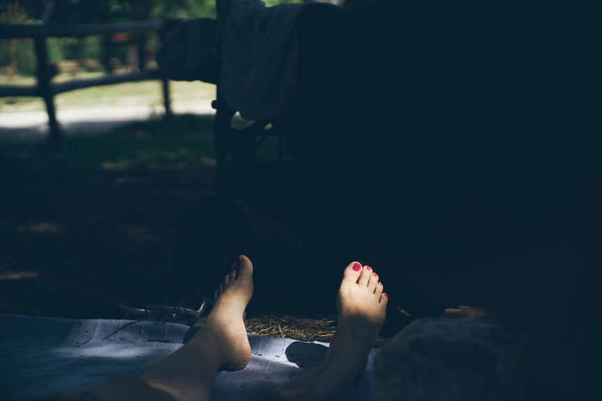 woman on blanket  with toes in the sun