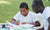 Young boy doing his school homework with his father.