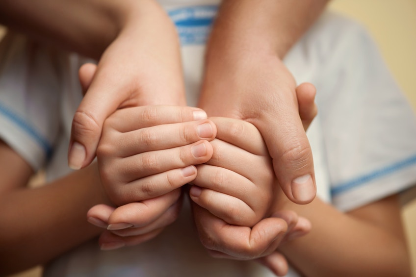 boy holding parents' hands