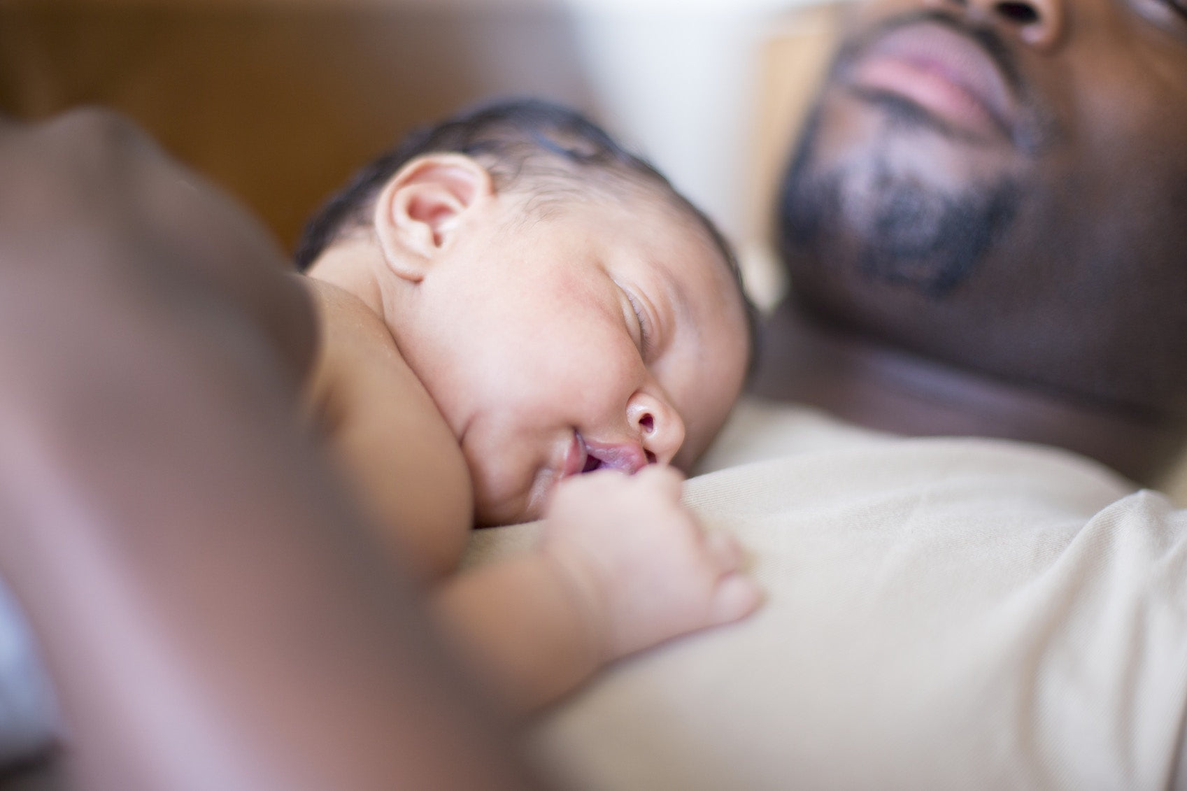 baby sleeping on father chest