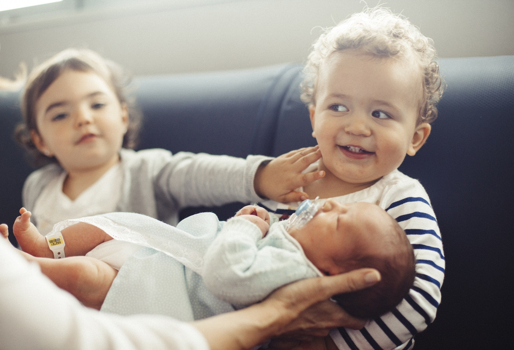 toddler holding new born baby