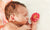 cute newborn baby with flower in small touching hand