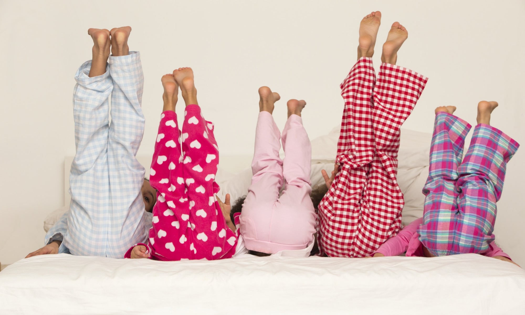 child lying on bed with her legs straight in the air