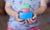  young boy playing with his building blocks holding a finished creation in his hands