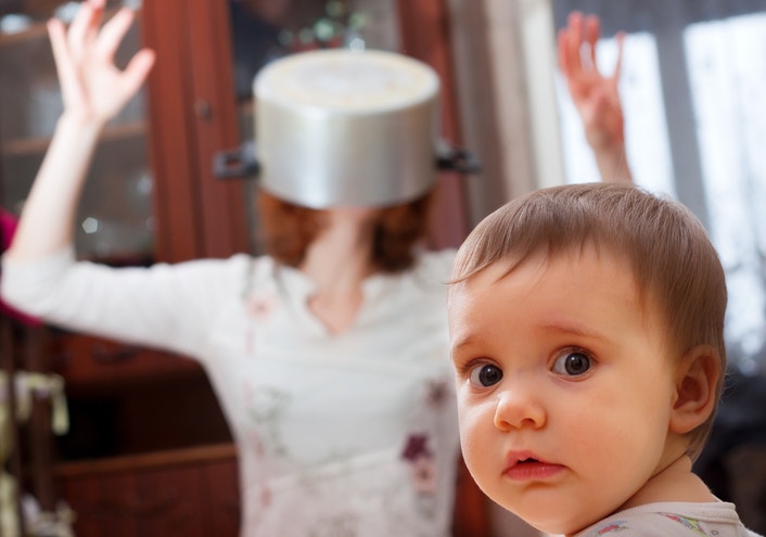 surprised baby boy , after playing pranks on mother in kitchen