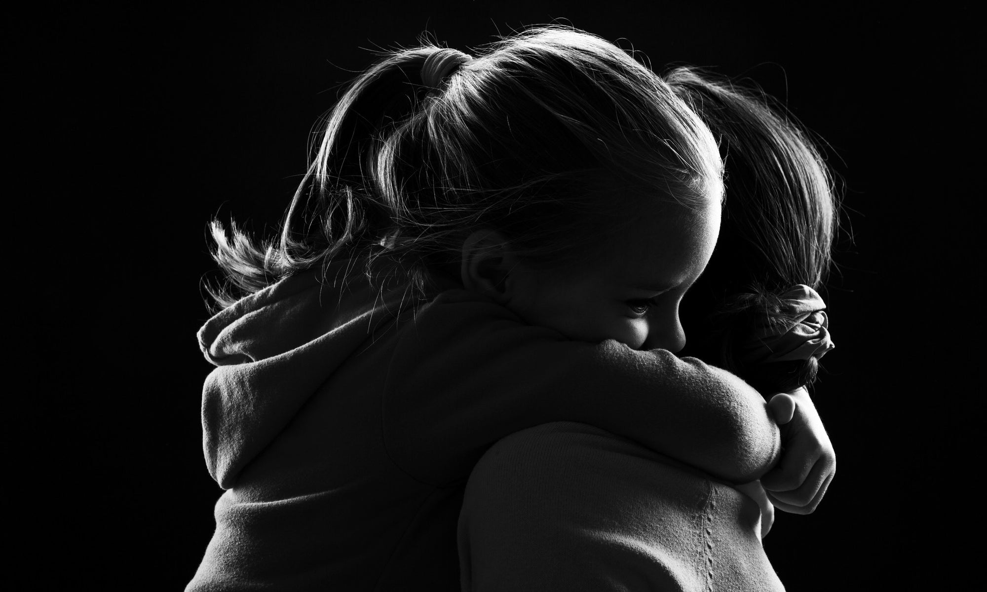 little daughter hugging mother holding tight