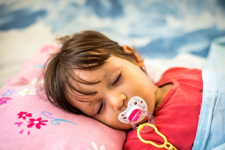 Young boy sleeping with his pacifier