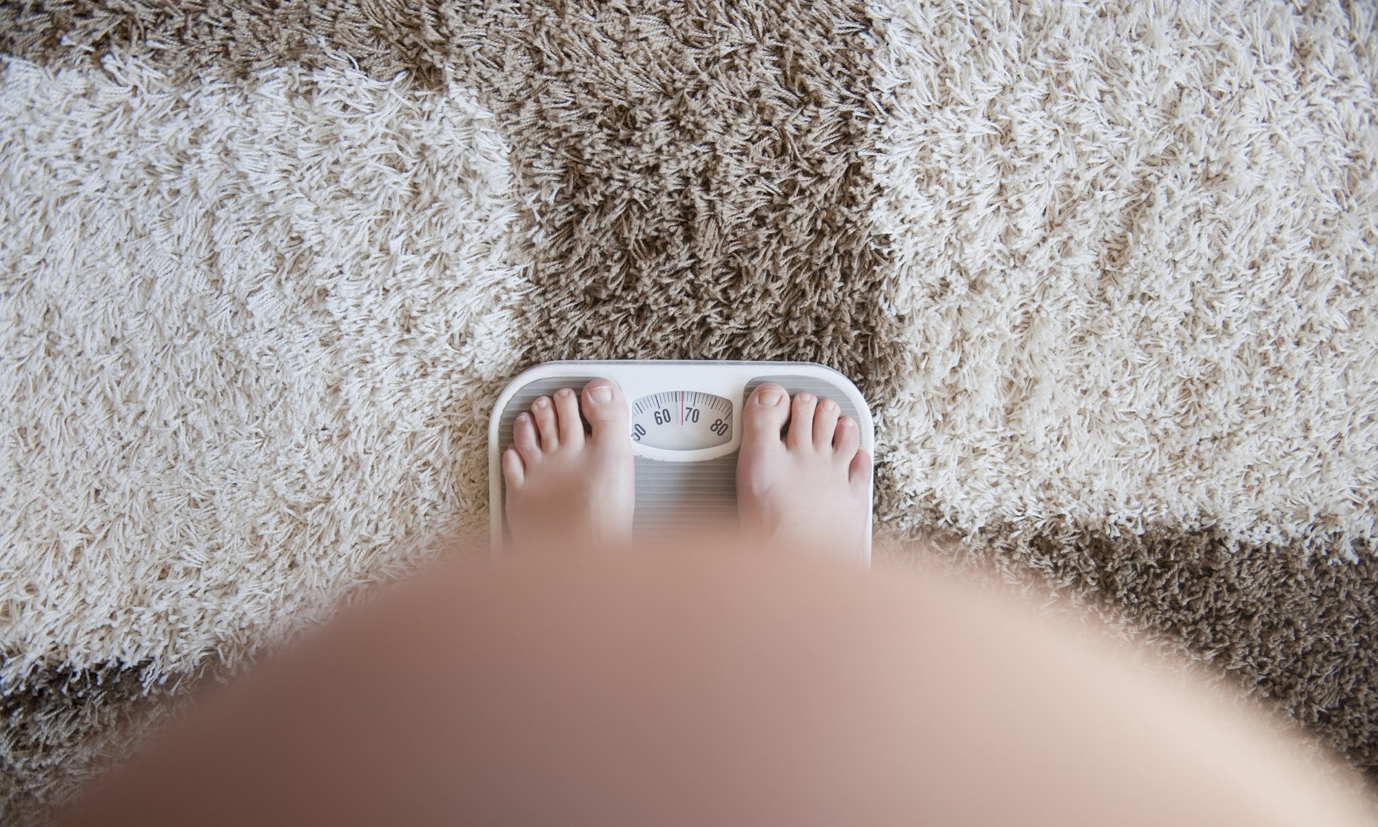 pregnant woman standing on weighing scales
