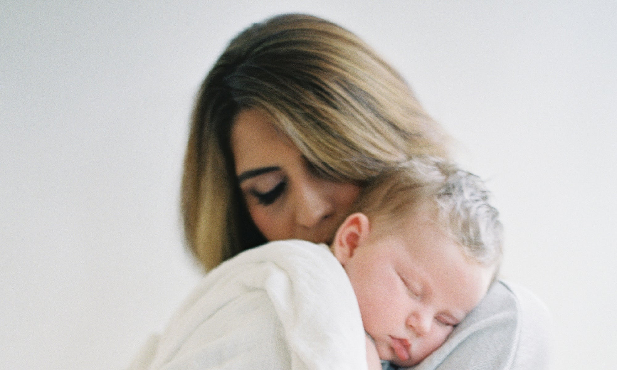 baby boy sleeping on mother's  shoulders