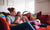 two women sitting on red couch holding new born baby