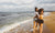 two beautiful women walking on the beach and smiling