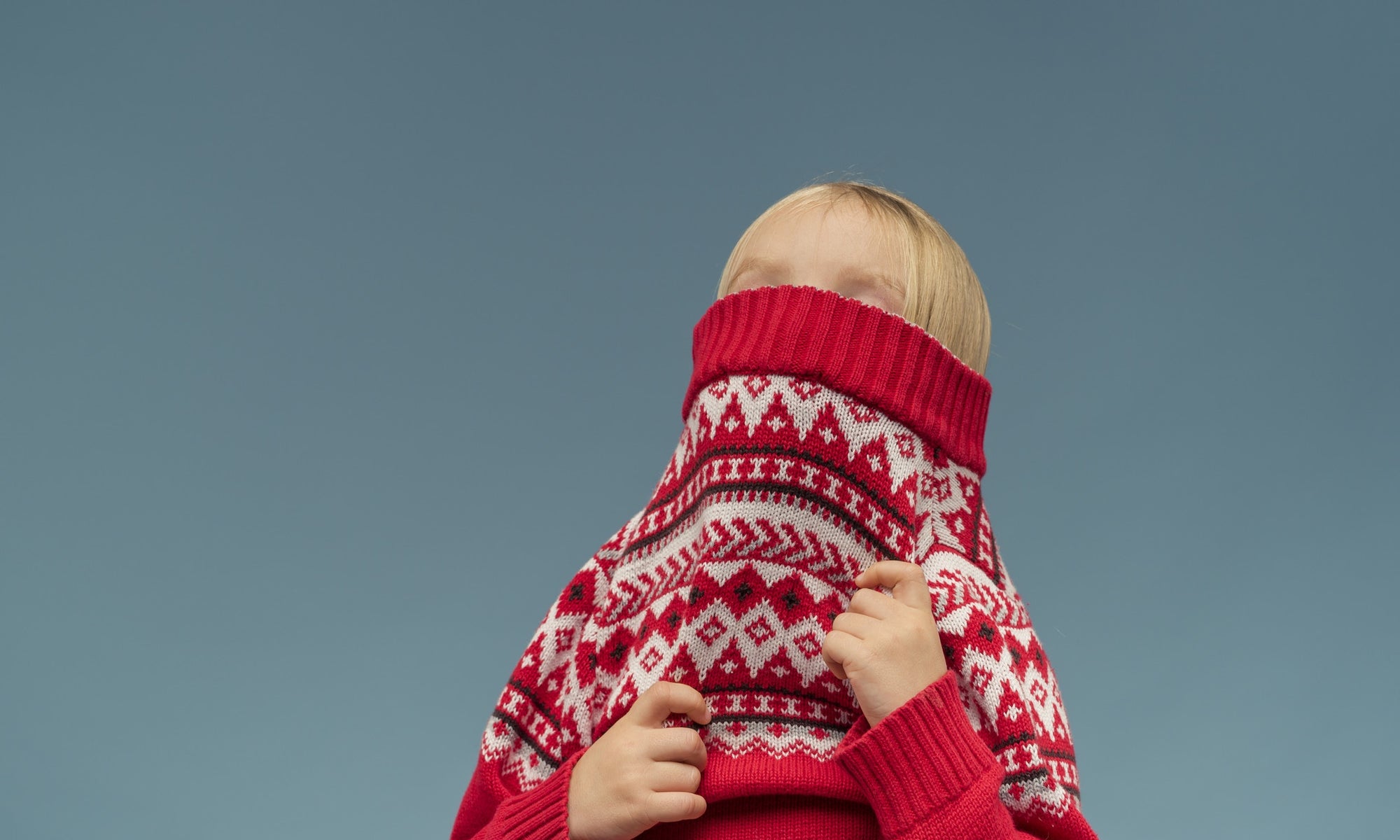 girl covers her face with red sweater