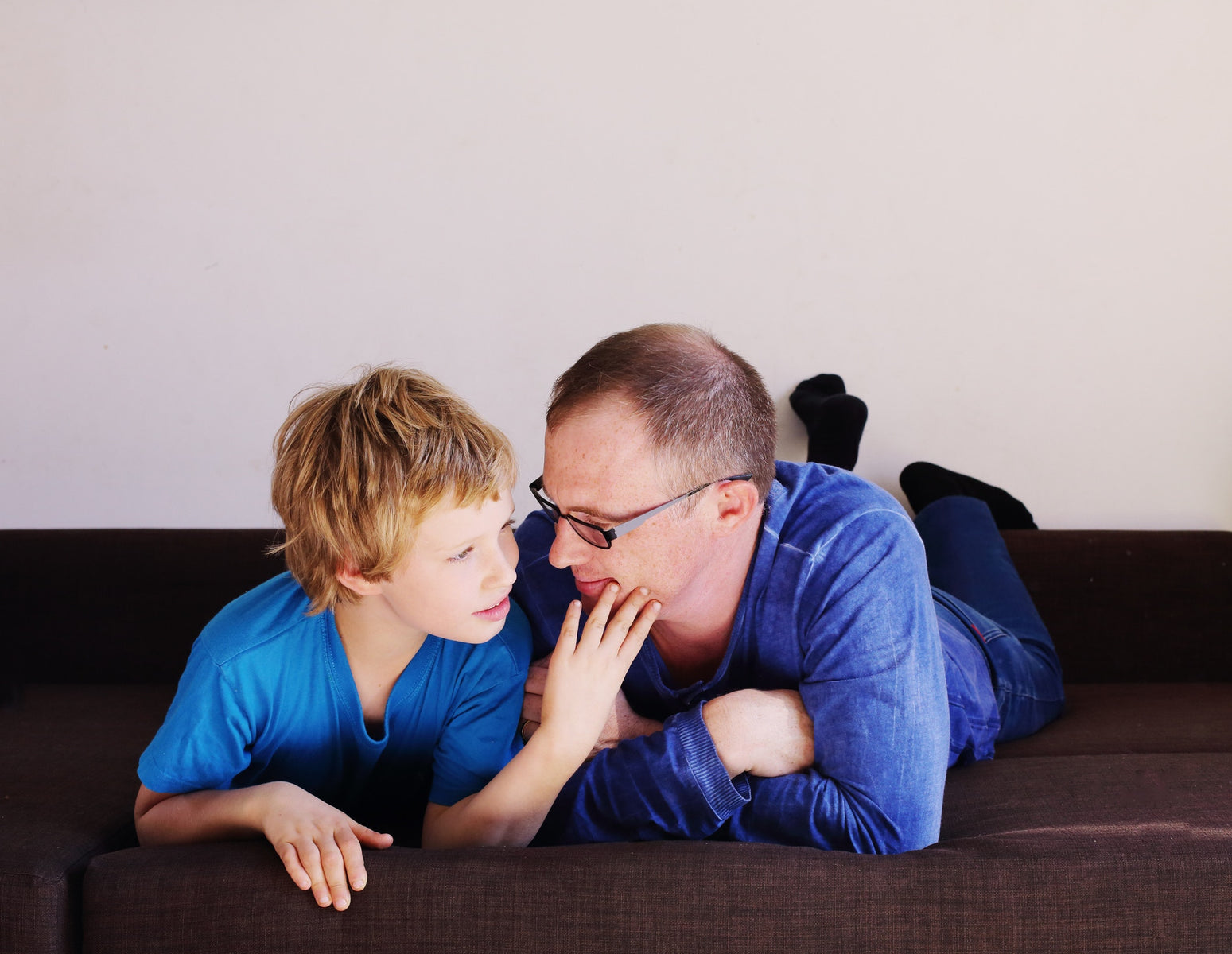 little boy and his father lying on bed