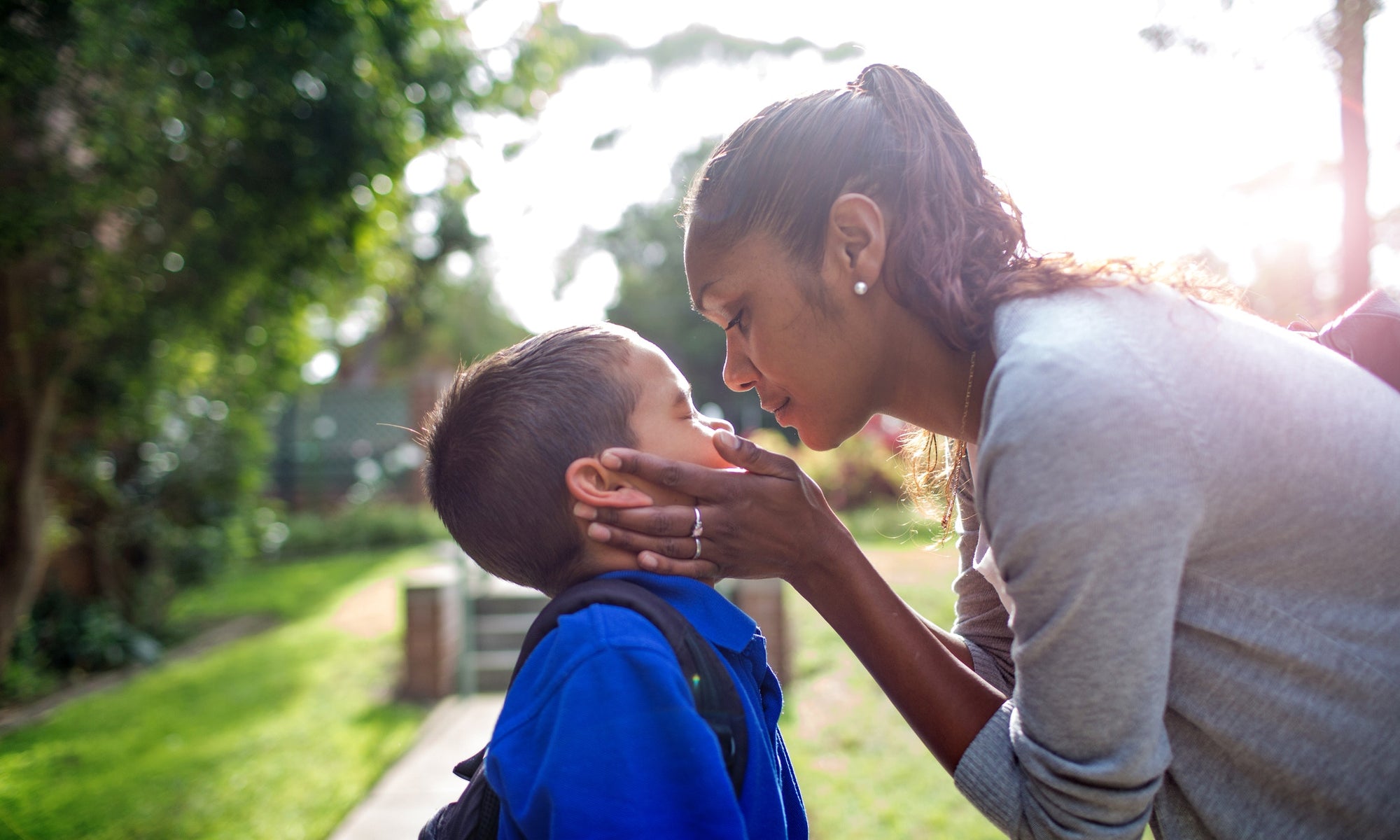 Mother cupping sons face in hands