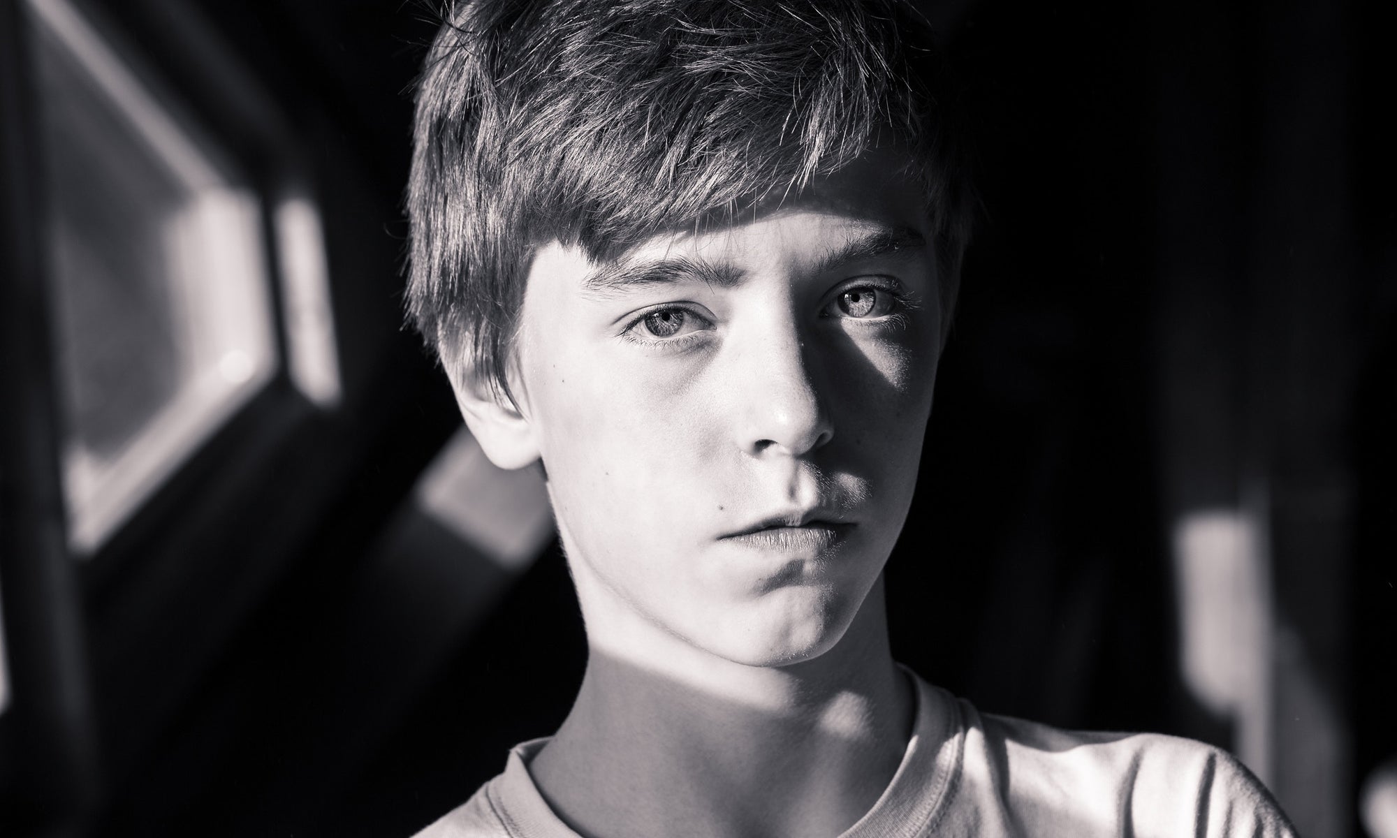 a boy looking at the camera  in the park in sun rays