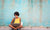 A woman sitting on the road and using laptop 