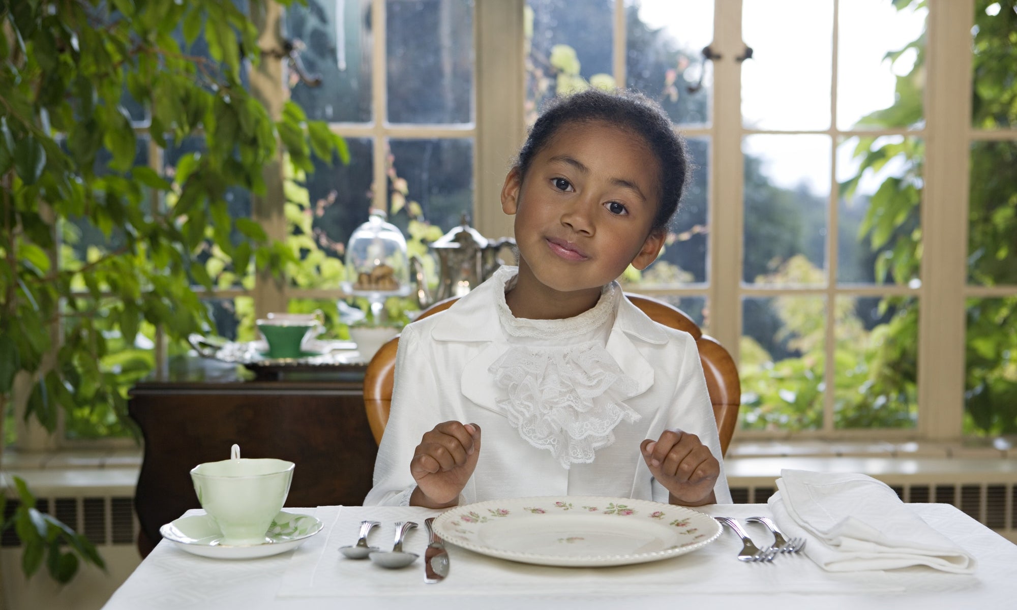 little girl sitting by dinner table