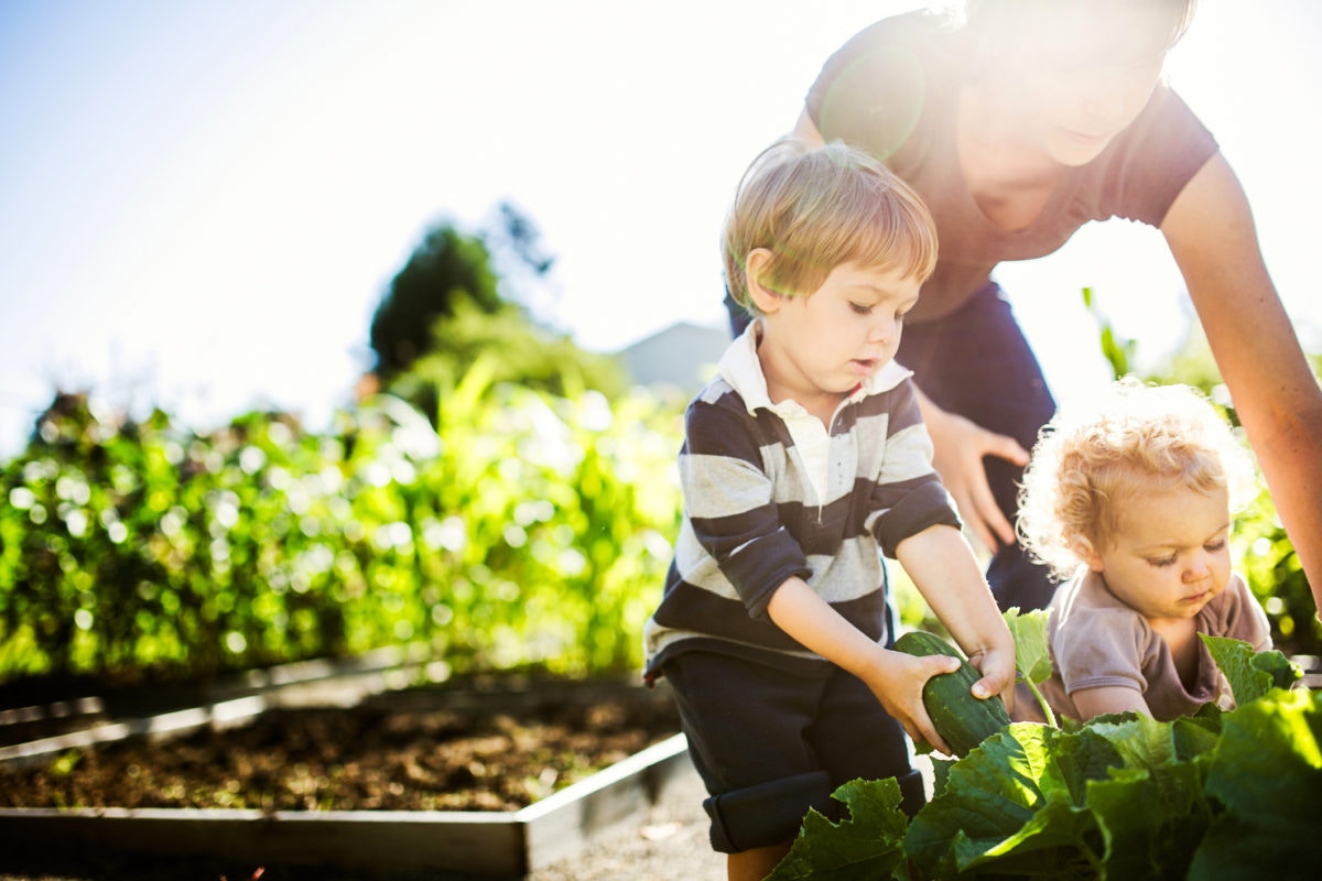 Mother Gardening With Her Kids 