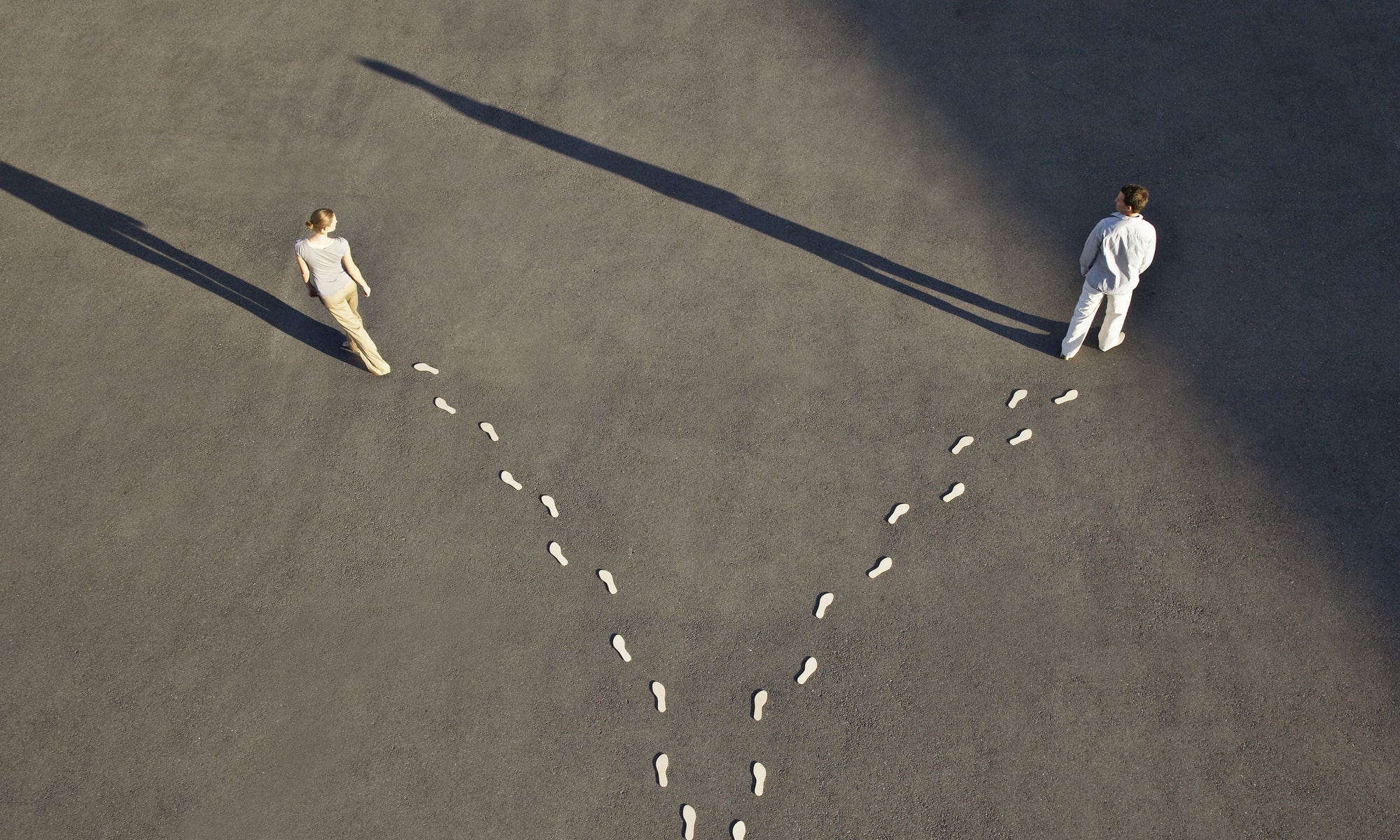 top view of man and women standing with footsteps behind them