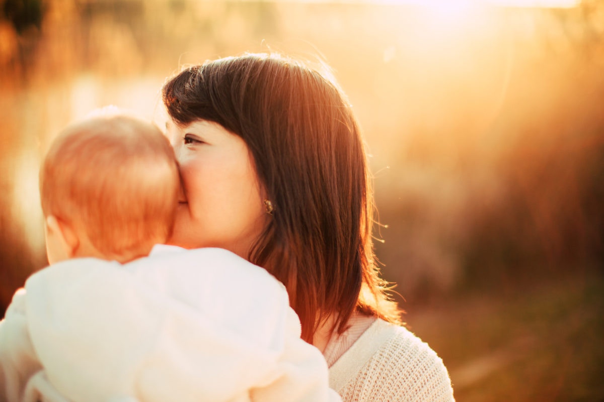 Mother and child at a sunny day forest, wishpering in ear