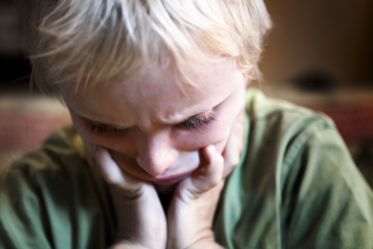 Depressed crying woman sitting with her head down