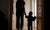 rear view of baby child holding mother hand walking on hallway