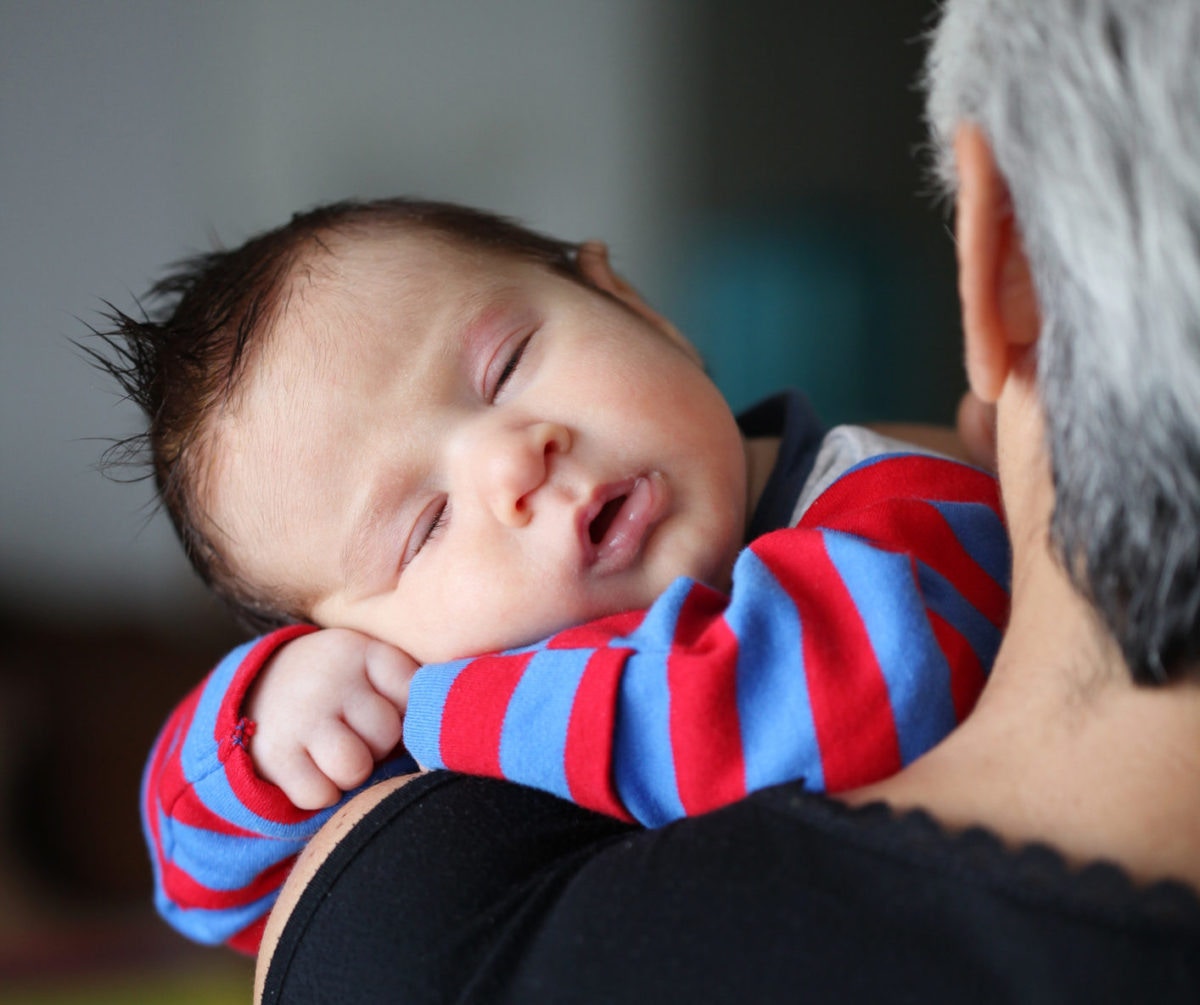 baby  sleeping on grandparent's  shoulders