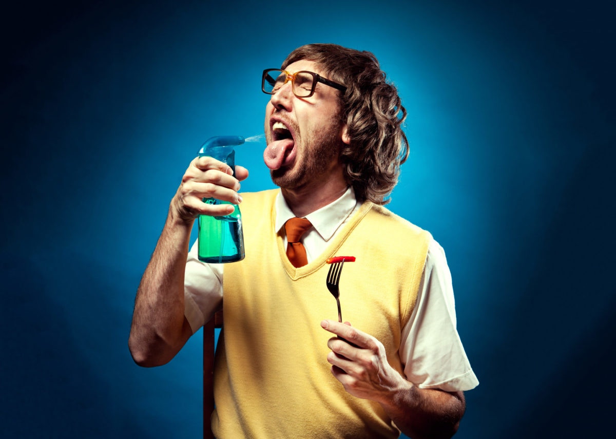 young man uses breath freshener.