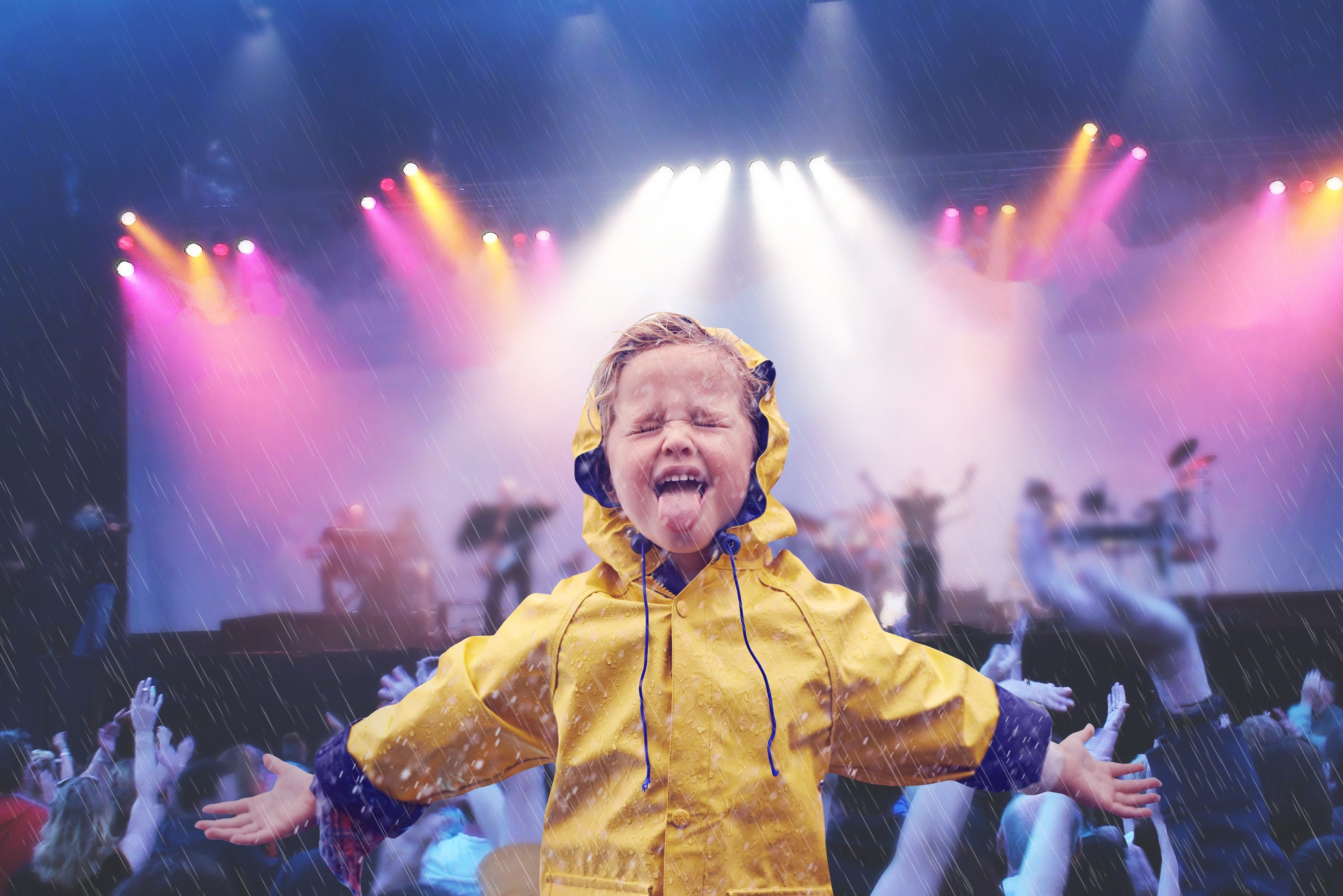 Cheerful boy wearing raincoat enjoying in rain  at music concert