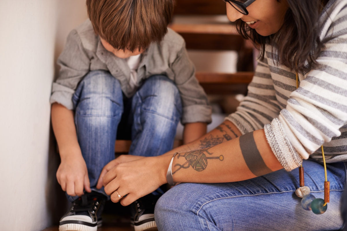 mother tying her son's shoelaces