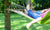 girl lying on colorful hammock at the garden reading book