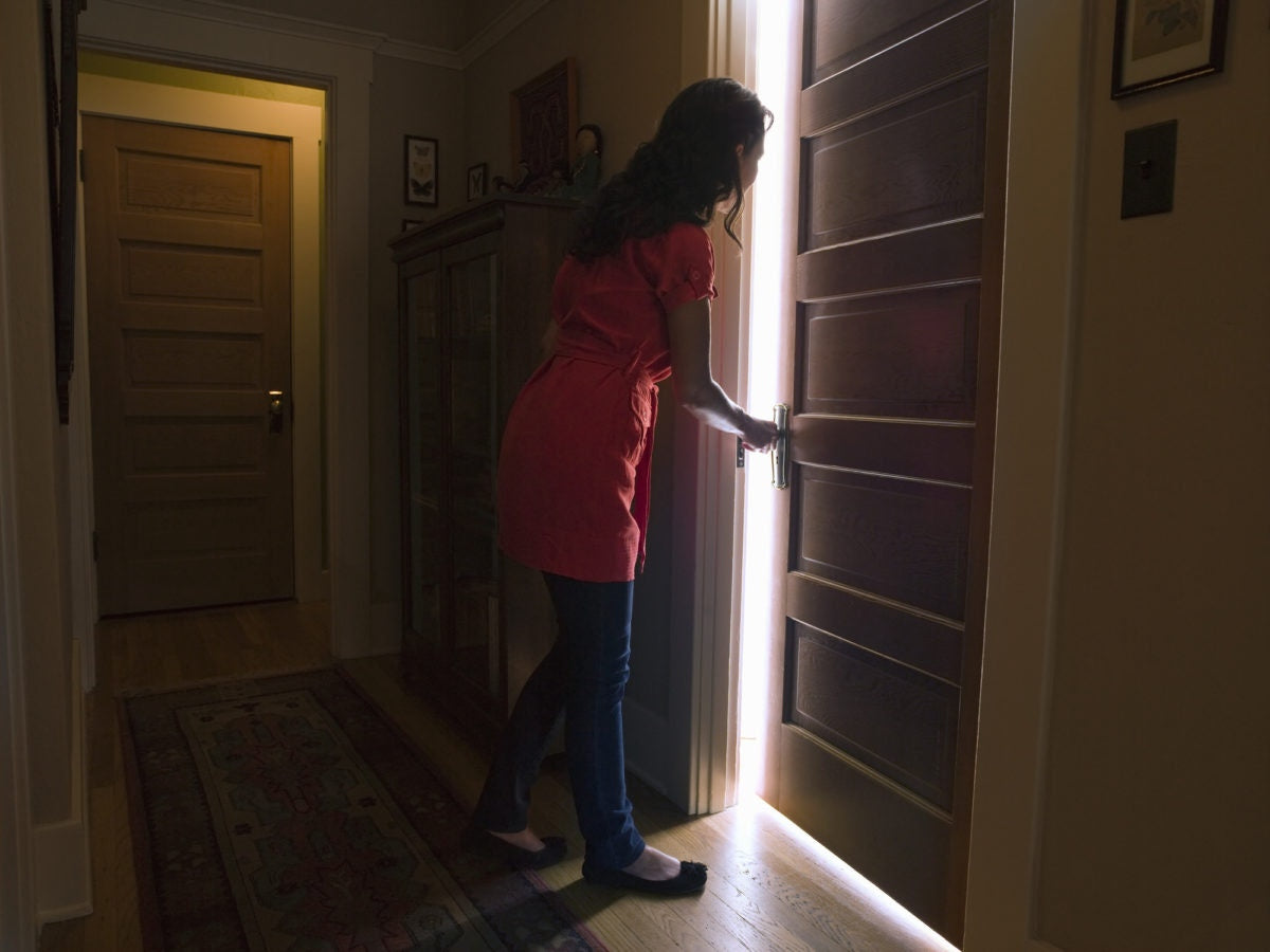 young happy woman peeking through door