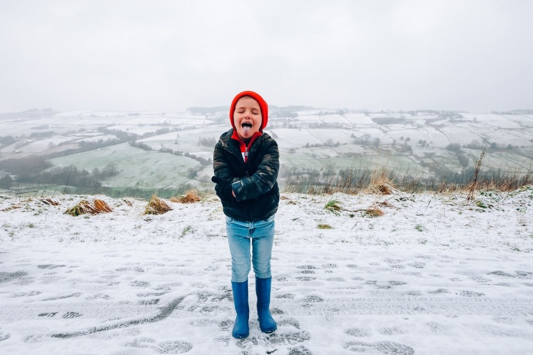 winter portrait of a young boy with red beanie and sweater 