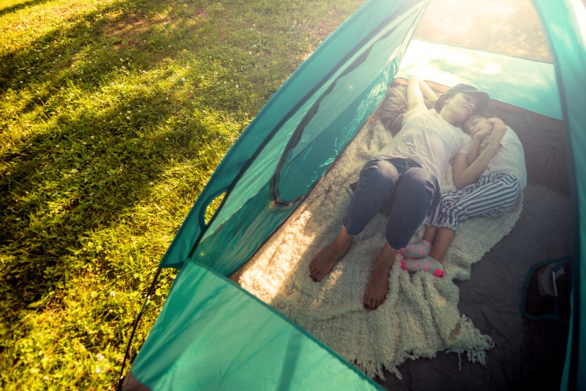 Mother sleeping with her child in a tent