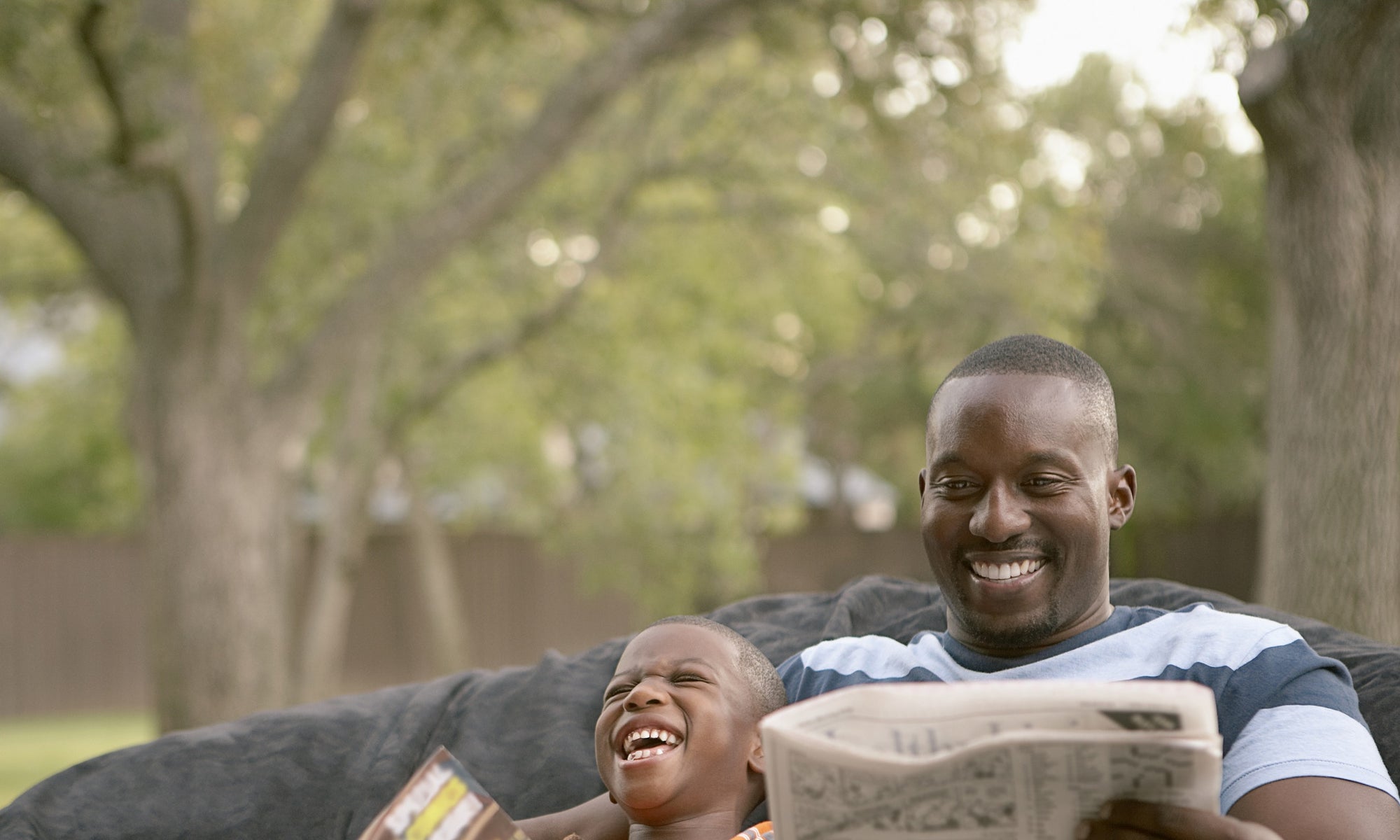 Happy father and son reading in the garden