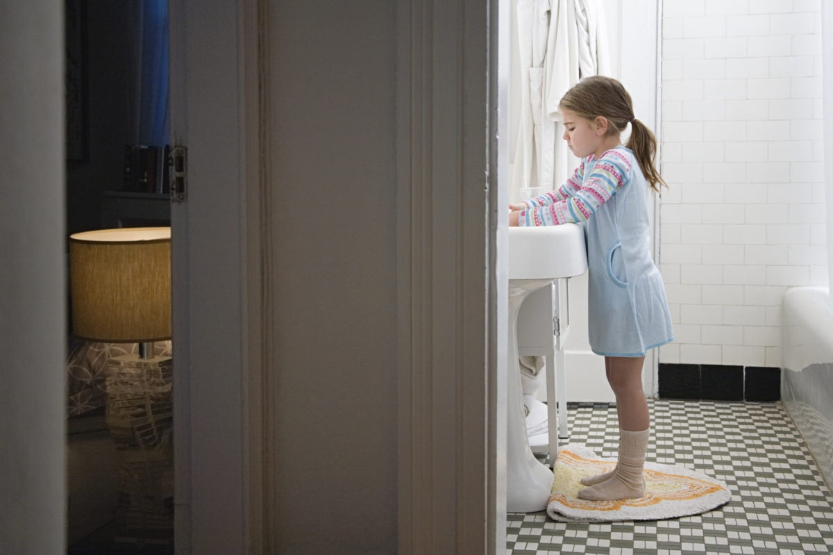 Little girl washing her hands in bathroom