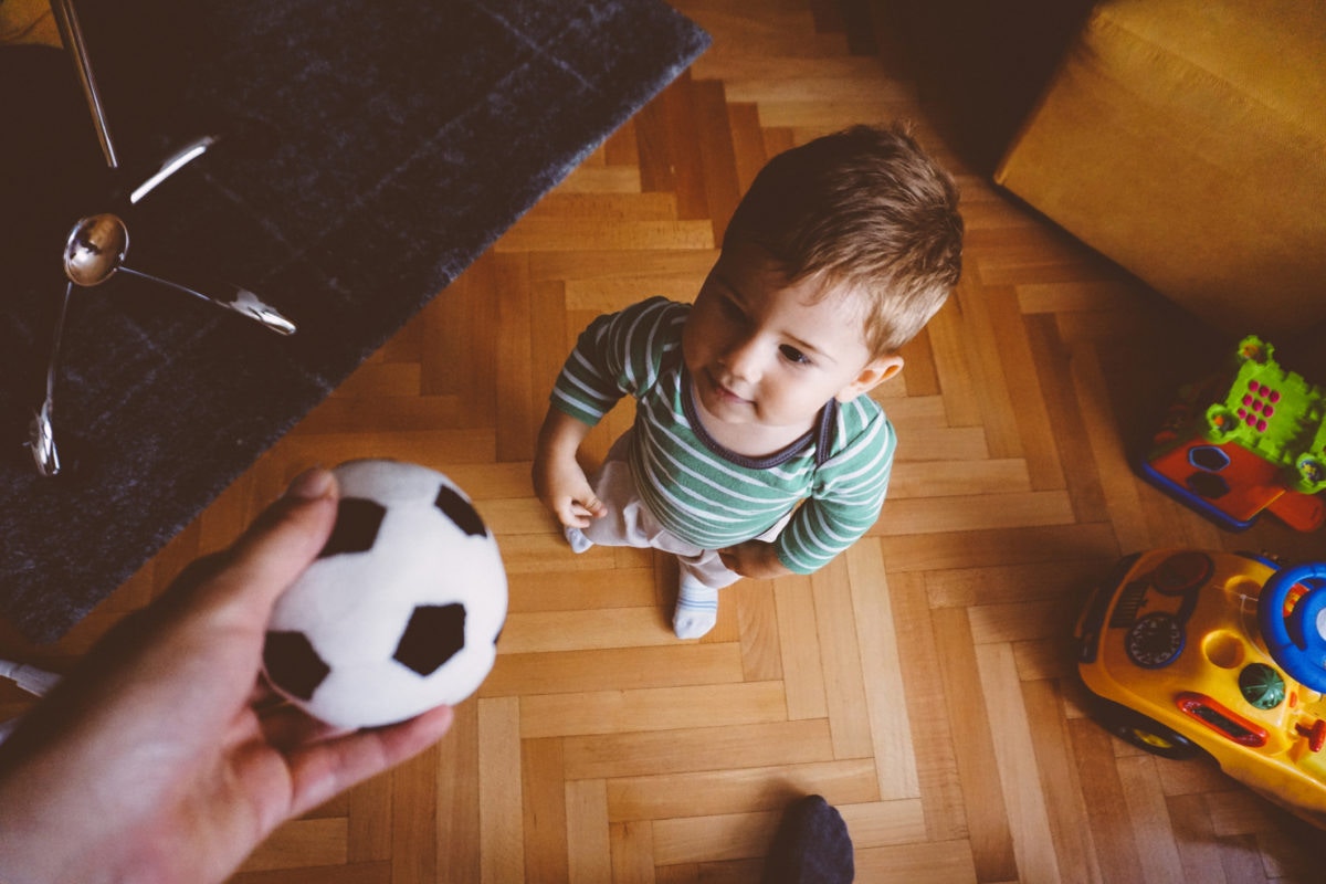 Cropped Hand Of Man Giving Soccer Ball To Son
