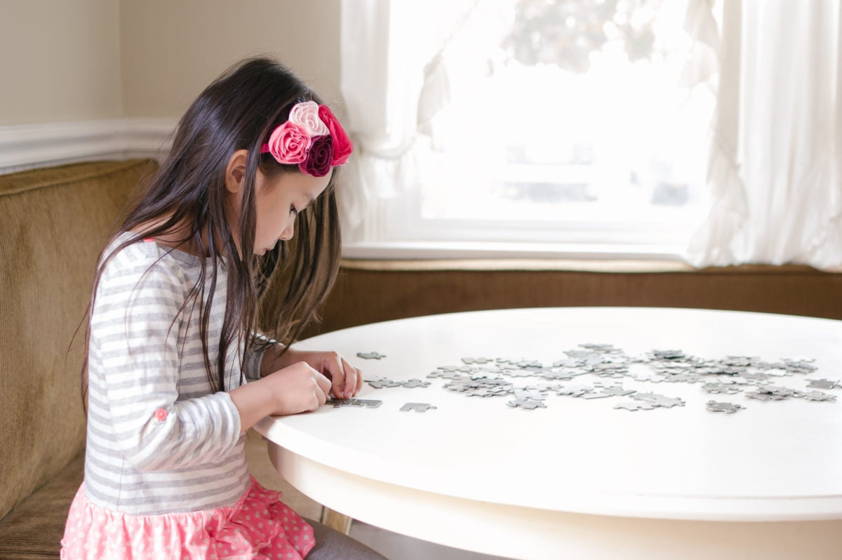 Little girl solving a puzzle