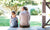 back view of young mother and daughter sitting on bench in veranda