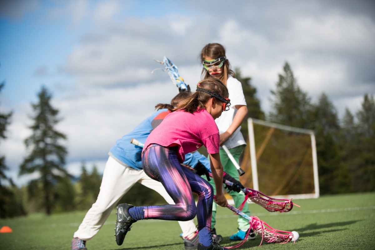 girls playing hockey outdoors