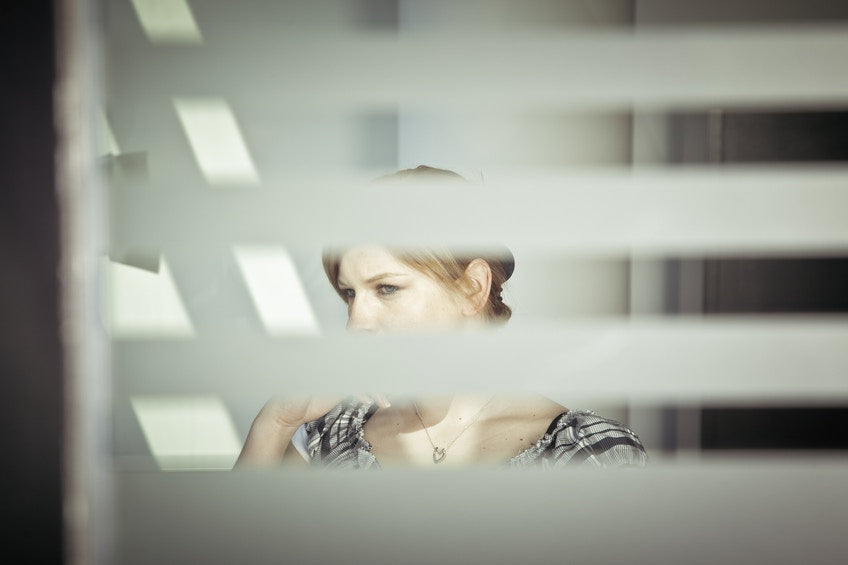 photo of a women through window blinds