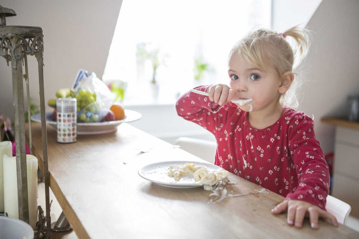 little girl eating pasta