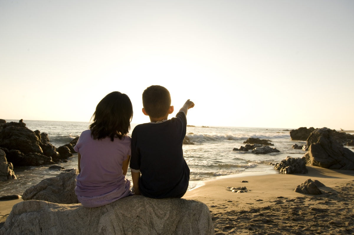 cousins on the beach , looking off sea shore