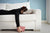 Woman lying in couch with face buried in pillow  and a book in her hand