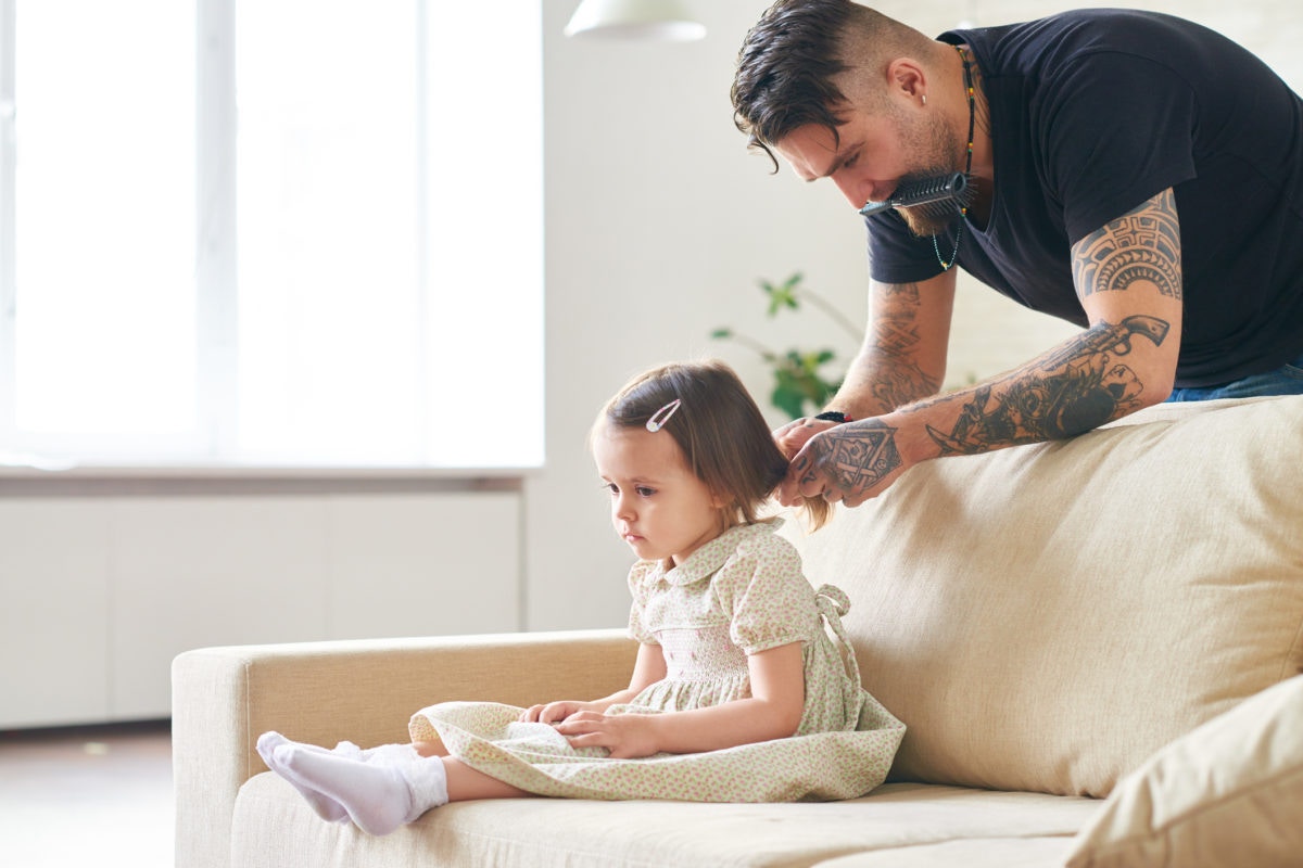 father cutting daughter's hair at home