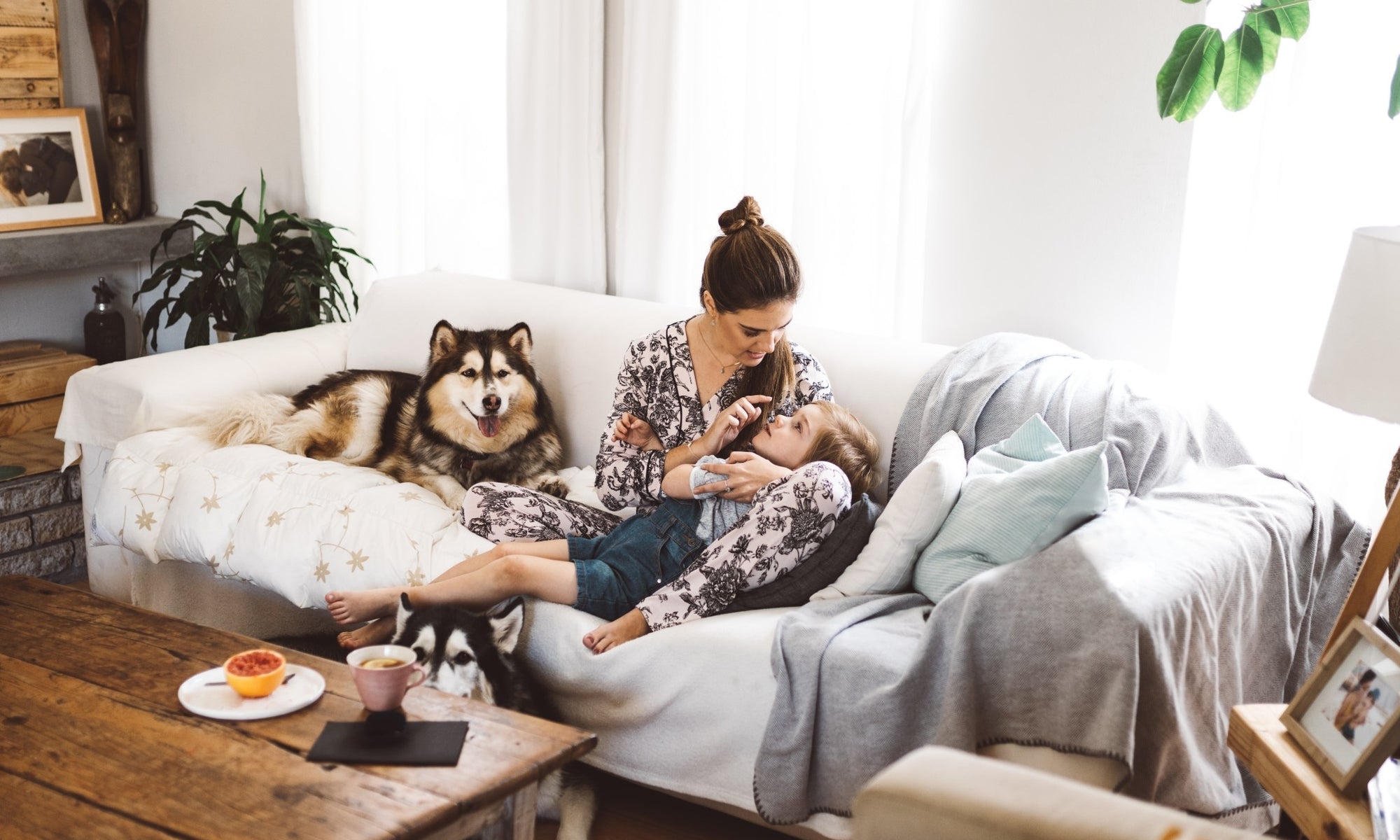 woman with child and dog on a couch